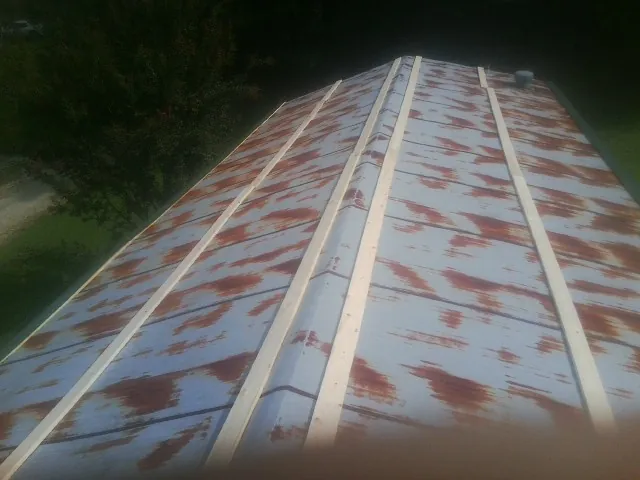 Rusted metal roof panels with new wood purlins before replacement — Storm Damage Roof Repair in Shickley by Roofing Brothers
